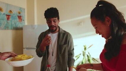 Friends testing snacks and having fun chatting at house party