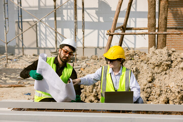 Engineers and Architect Caucasian looking at blueprint of building construction, planning the work in a professional. inspector is looking at steel structure and materials at construction site.