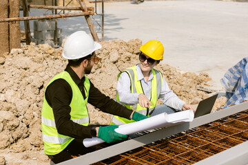 Engineers and Architect Caucasian looking at blueprint of building construction, planning the work in a professional. inspector is looking at steel structure and materials at construction site.