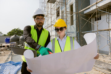 Engineers and Architect Caucasian looking at blueprint of building construction, planning the work in a professional. inspector is looking at steel structure and materials at construction site.