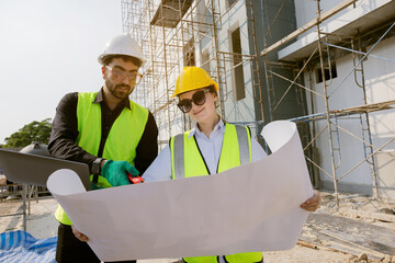 Engineers and Architect Caucasian looking at blueprint of building construction, planning the work in a professional. inspector is looking at steel structure and materials at construction site.