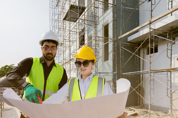 Engineers and Architect Caucasian looking at blueprint of building construction, planning the work in a professional. inspector is looking at steel structure and materials at construction site.