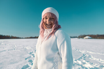 Happy pink hair woman tourist having a video call or taking a selfie in winter holidays in a snowy...