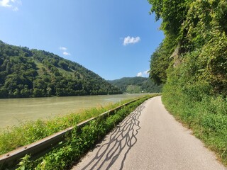 Beautiful bike path at famous Danube River: Donauradweg next to the river on a sunny day with clear blue sky and copy space for text, austria