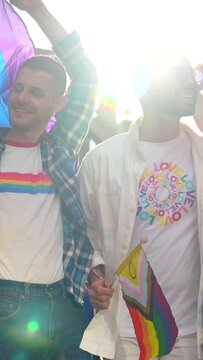 Homosexual friends having fun at gay pride party in the city, diversity of young people, demonstration with the rainbow flags, lgbt concept