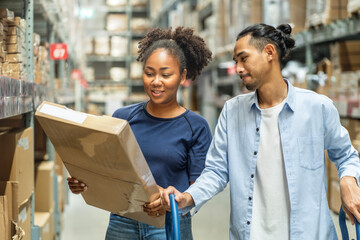 Black African American woman holding boxes of furniture, happy to buy, shopping with her Asian male...