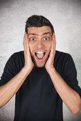 Uomo adulto stupito grida con le mani sul viso