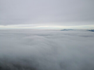 Wild Carpathian forest cinematic aerial view. Drone flying over the clouds