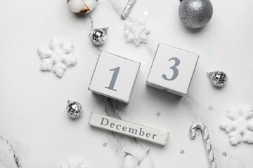 Calendar with date 13 DECEMBER and Christmas decor on white marble background