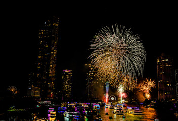 Firework show to celebrate of the new year 2024 along Chao Praya River with the night scene on Asiatique landmark side in Bangkok city, Thailand.