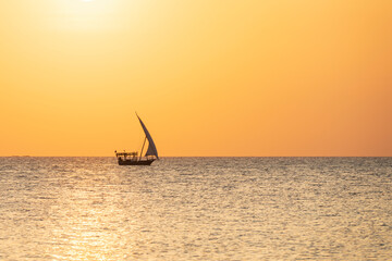 Summer concept, dhow boat sails in the ocean at sunset, Zanzibar, Tanzania. - obrazy, fototapety, plakaty