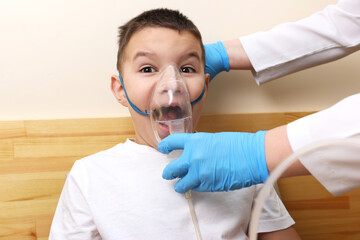 The boy is preparing for the nebulizer inhalation procedure.