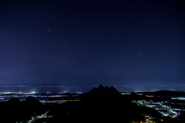 Fototapeta na wymiar View of the stars and the silhouette of Pieterboth mountain from top of Le Pouce mountain at night in Mauritius