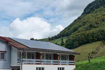 Solar panels installed on the roof of hotel by hillside and blue sky