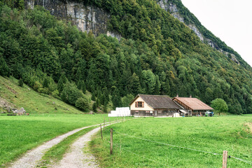 Rustic wooden house on green hill in Alpstein mountain during summer at Switzerland