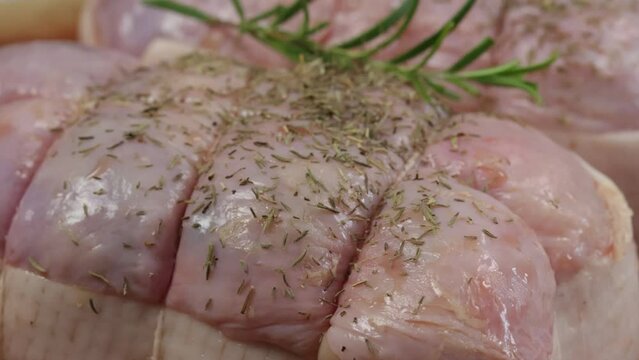 herbes et &eacute;pices vers&eacute;s sur un r&ocirc;ti de dinde cru