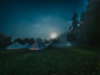 camping in a moody foggy night with a bright moon