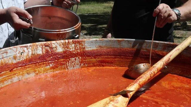 Tomato soup with pasta is a dish of Polish cuisine. Hot Zupa pomidorowa in a large cauldron at the field kitchen at a food fair. A popular soup made from grated tomatoes in their own juice.