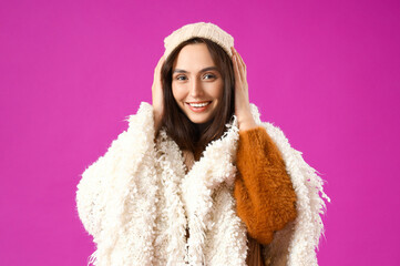 Young woman with warm plaid on purple background