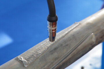 Automatic pipes welding MIG MAG process closeup - welding torch and patch on welded detail