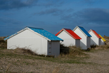 Gouville, France - 12 30 2023: View of colorful bathing wooden cabins of Gouville on the dunes.