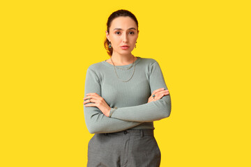 Fashionable young woman with stylish jewellery on yellow background