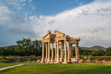 Standing gate of the ancient city of Afrodisias with colorful sky and rain clouds in the background
