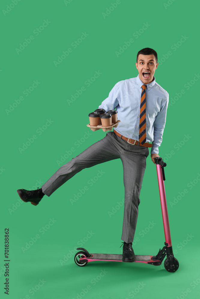 Poster Handsome businessman with coffee cups and kick scooter on green background