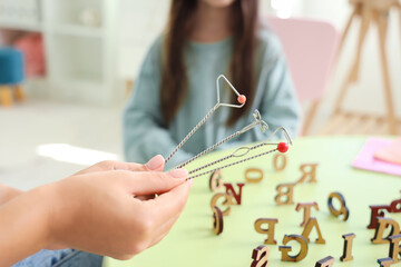 Female speech therapist with logopedic probes in office, closeup