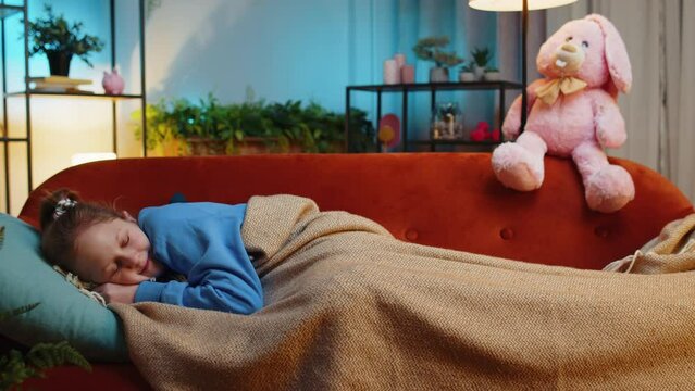 Tired preteen child girl lying down in bed taking a rest at home. Carefree teenager female kid napping, falling asleep on comfortable sofa with pillows. Closed her eyes enjoy evening night nap alone