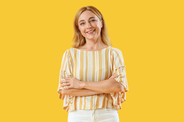 Mature woman smiling on yellow background