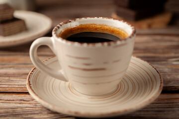 Cup of hot aromatic coffee with sweets on the table