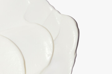 White cosmetic cream smeared on a white background.
