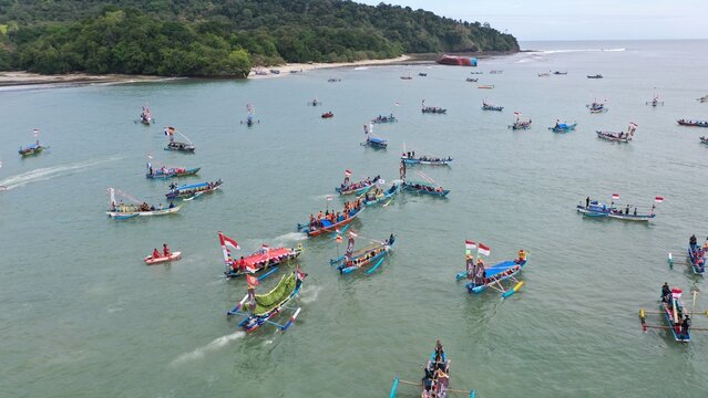 Pangandaran Beach, West Java, Indonesia. A stunning scene where a group of tourists celebrate the beauty of nature while enjoying the hajat laut, an interesting cultural procession.
