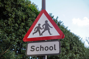 School children crossing road sign warning motorists. caution sign beware of pedestrians crossing road 