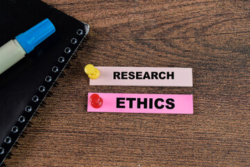 Concept of Research Ethics write on sticky notes isolated on Wooden Table.