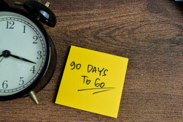 Concept of 90 Days To Go write on sticky notes isolated on Wooden Table.