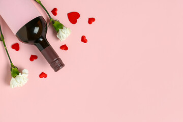 Bottle of wine with carnations on pink background. Valentine's Day celebration
