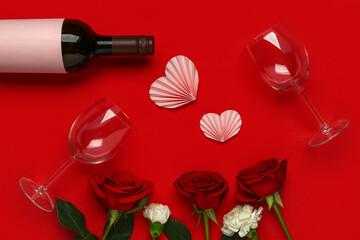 Obraz na płótnie Canvas Bottle of wine with beautiful flowers and glasses on red background. Valentine's Day celebration
