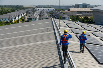 Back view solar engineer workers working with  solar panels on factory roof