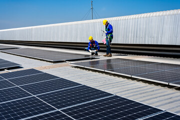 Solar engineer men working with photovoltaic panels on the roof of a building