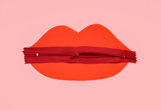 Paper lips with zip on pink background. Domestic violence concept
