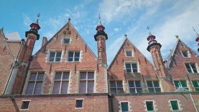 Low angle shot of an Ancient vintage architecture building on a sunny bright day with the clear blue sky and clouds in background in bruge, Brugge, brussels Belgium