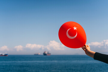 A girl with a red Turkish balloon in her hand on the Istanbul pier. Turkish festive balloon on the...