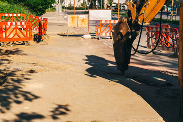 a jackhammer on a loader for breaking asphalt. dismantling of the road for laying communications....