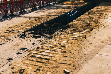 an open pit with a loader for laying pipes.  a paved road to improve communications in the city....