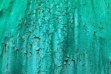 Old green paint on metal with rust.