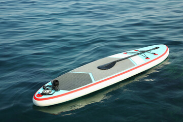 One SUP board with paddle on water in sea
