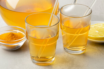Glasses with fresh made hot Curcuma drink and lemon close up