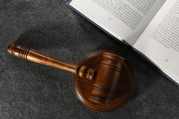 Law concept. Gavel and book on grey textured table, top view